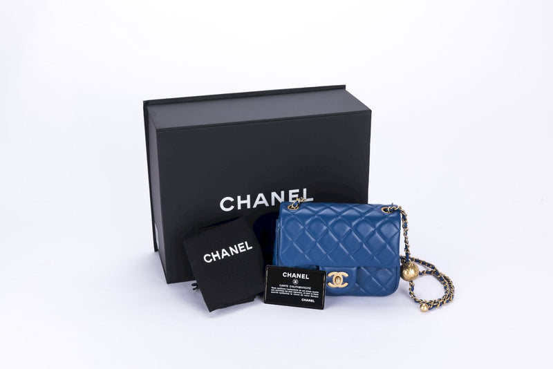 CHANEL. Navy blue quilted canvas bag, a gold metal chai…